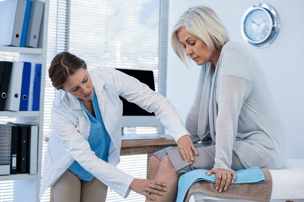 Ein Patient mit Arthrose, der eine Therapie benötigt, wird von einem Arzt untersucht